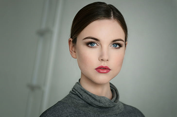 a woman with red lipstick and grey turtleneck