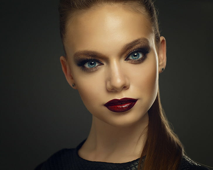 a woman with blue eyes and red lipstick